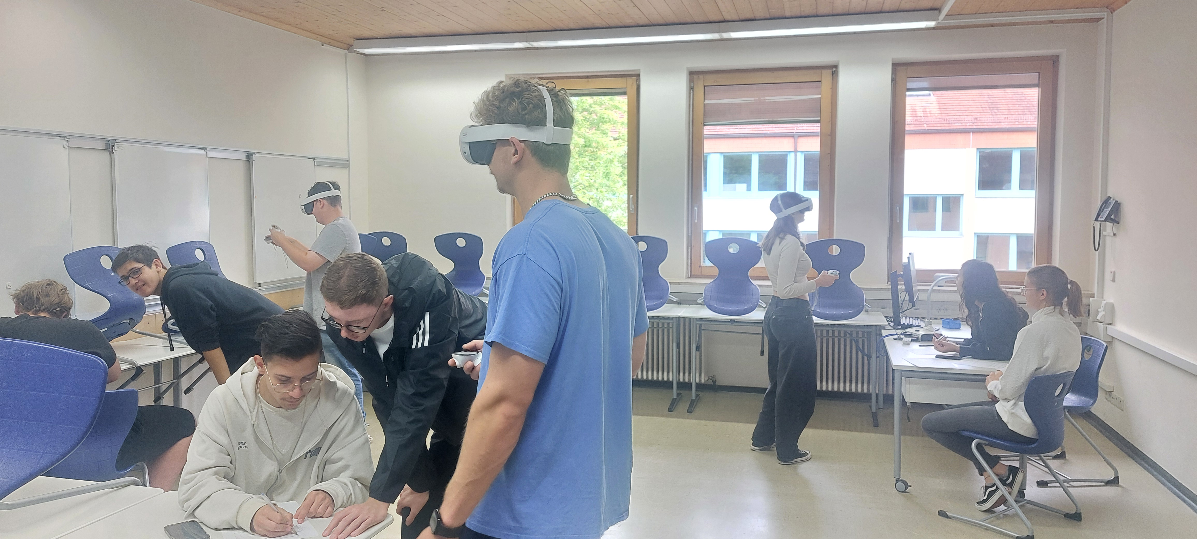 Mehrere Schülerinnen und Schüler mit VR-Brille im Klassenraum