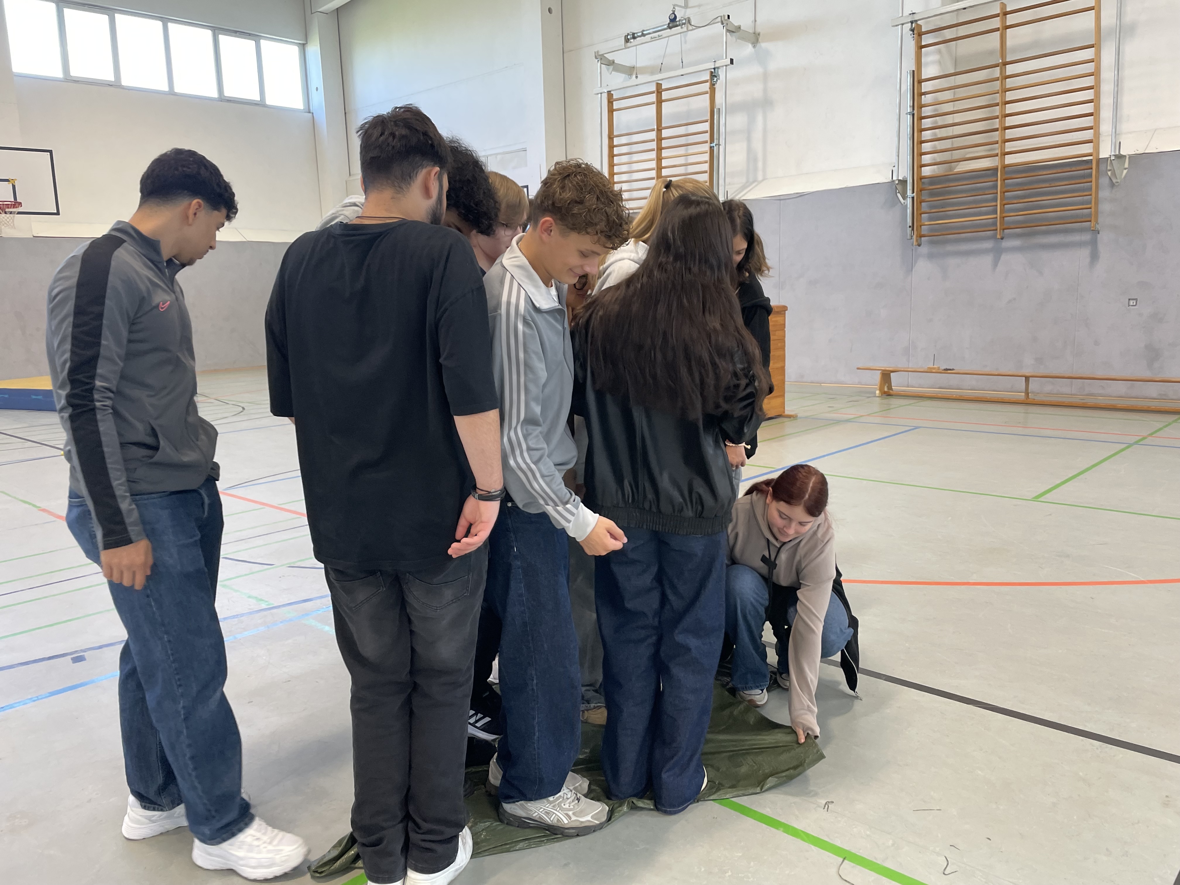 Schülerinnen und Schüler stehen auf grüner Matte