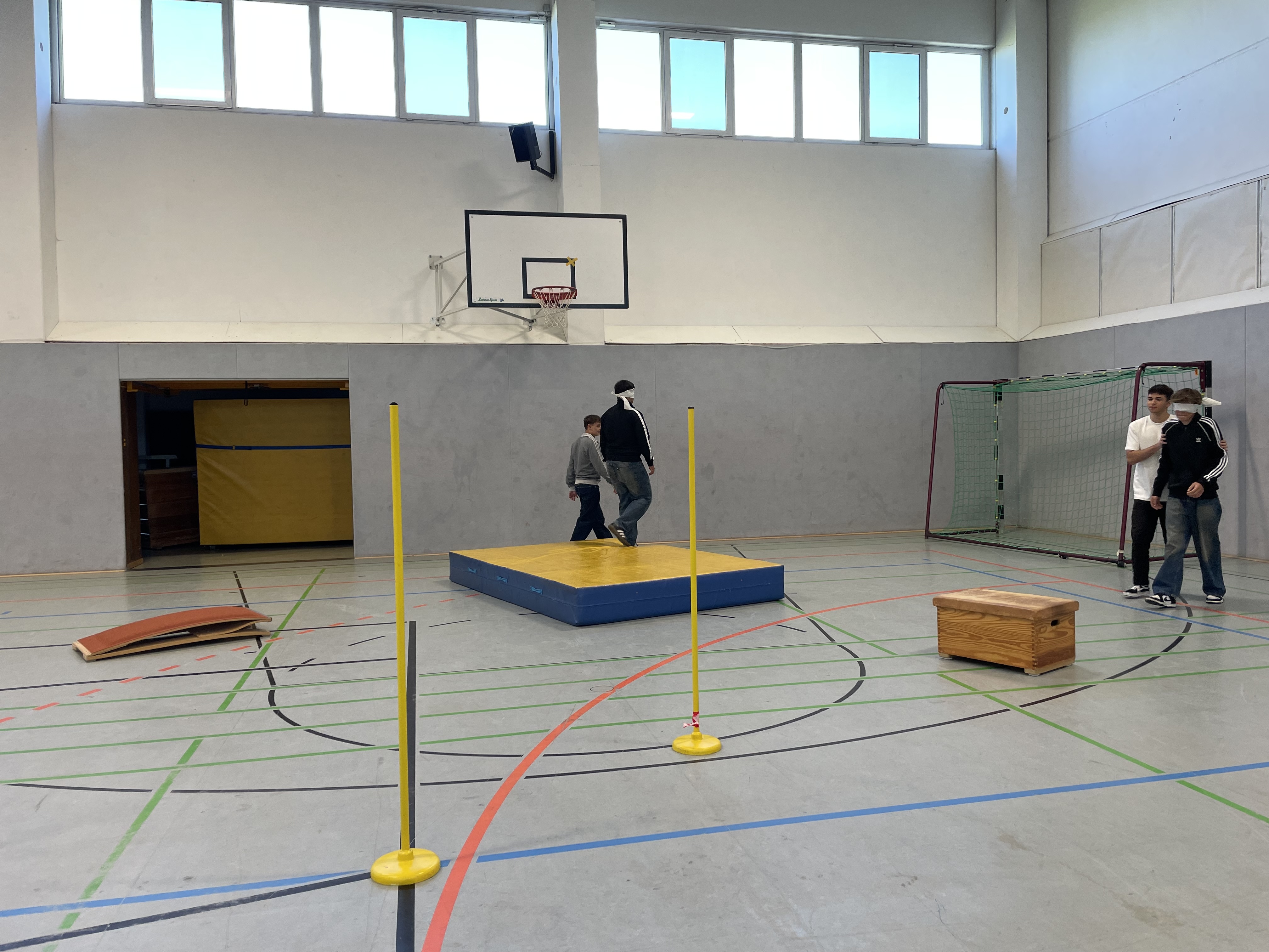 Schülerpärchen laufen Parkour, einer führt, einer mit Augenbinde