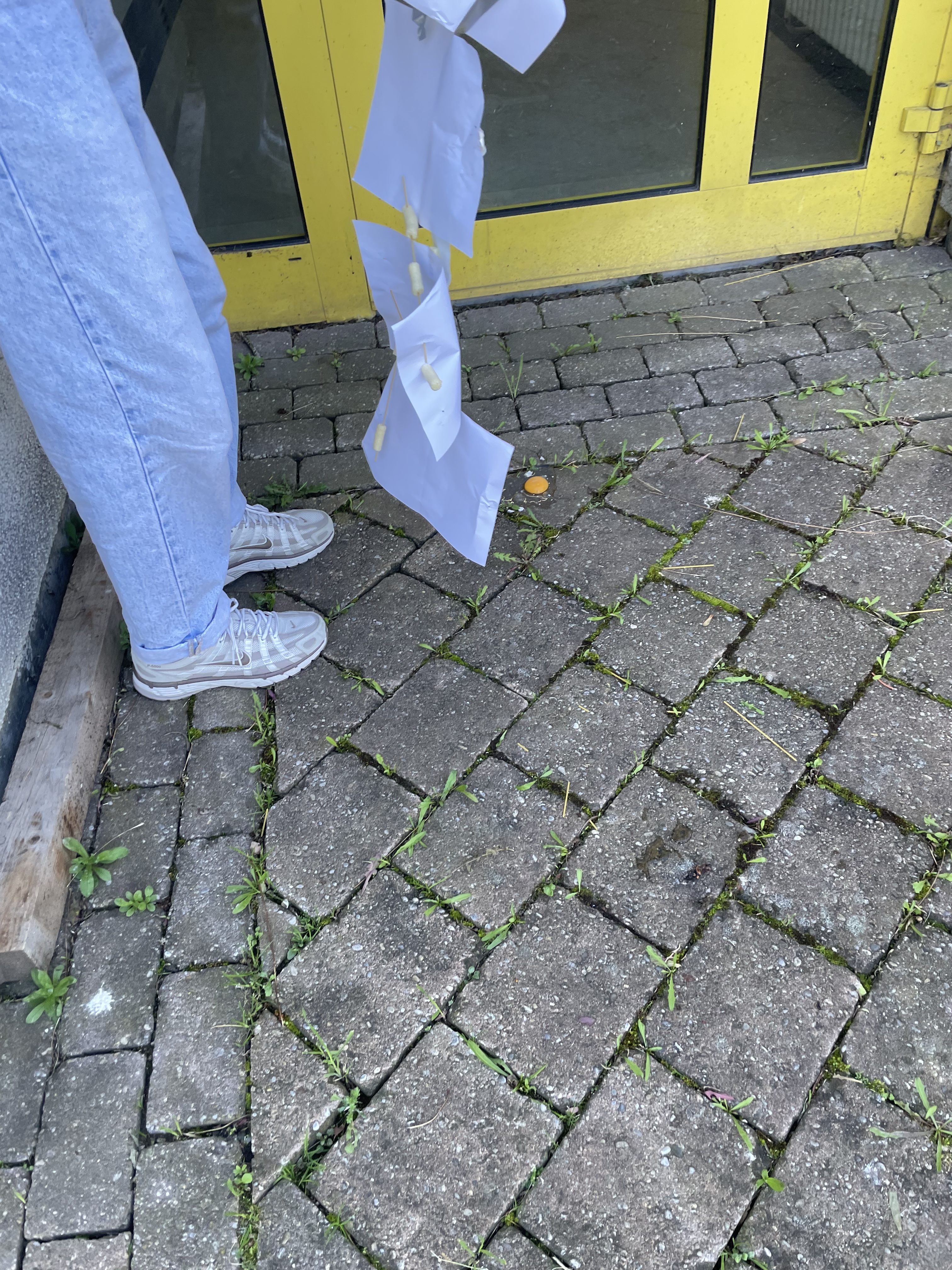 Schülerbeine, zerbrochenes Ei auf dem Boden