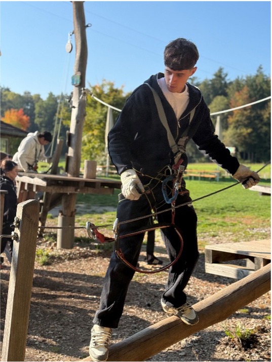 Person mit Kletterausrüstung auf Balken