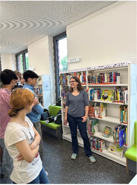 Mehrere Personen stehend vor Bücherregal