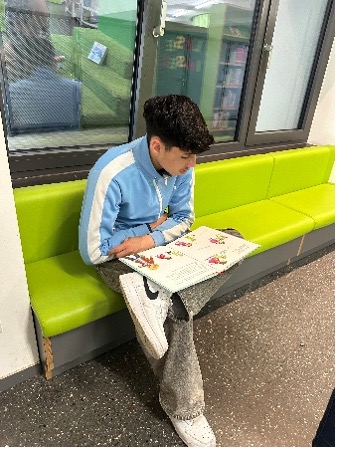 Männliche Person sitzend mit Buch 