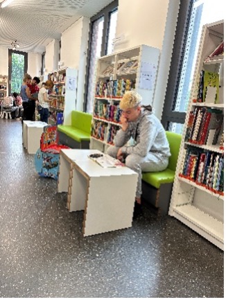 Männliche Person sitzend und lesend 