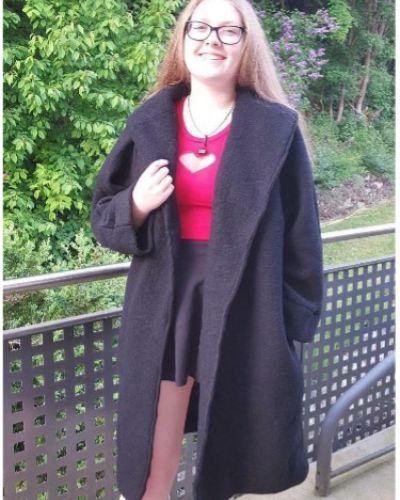 Schülerin mit Mantel, stehend