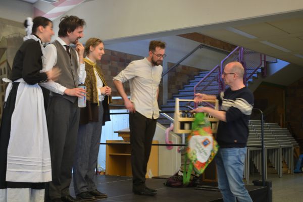 Überreichen eines Geschenkes für Schauspieler und Schauspielerinnen durch Lehrkraft