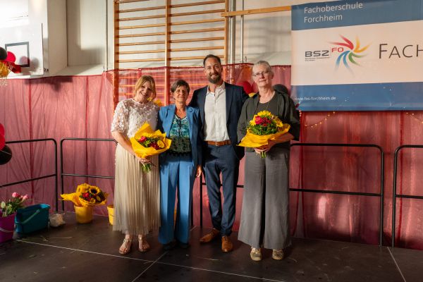 Personen stehend und mit Blumenstrauß