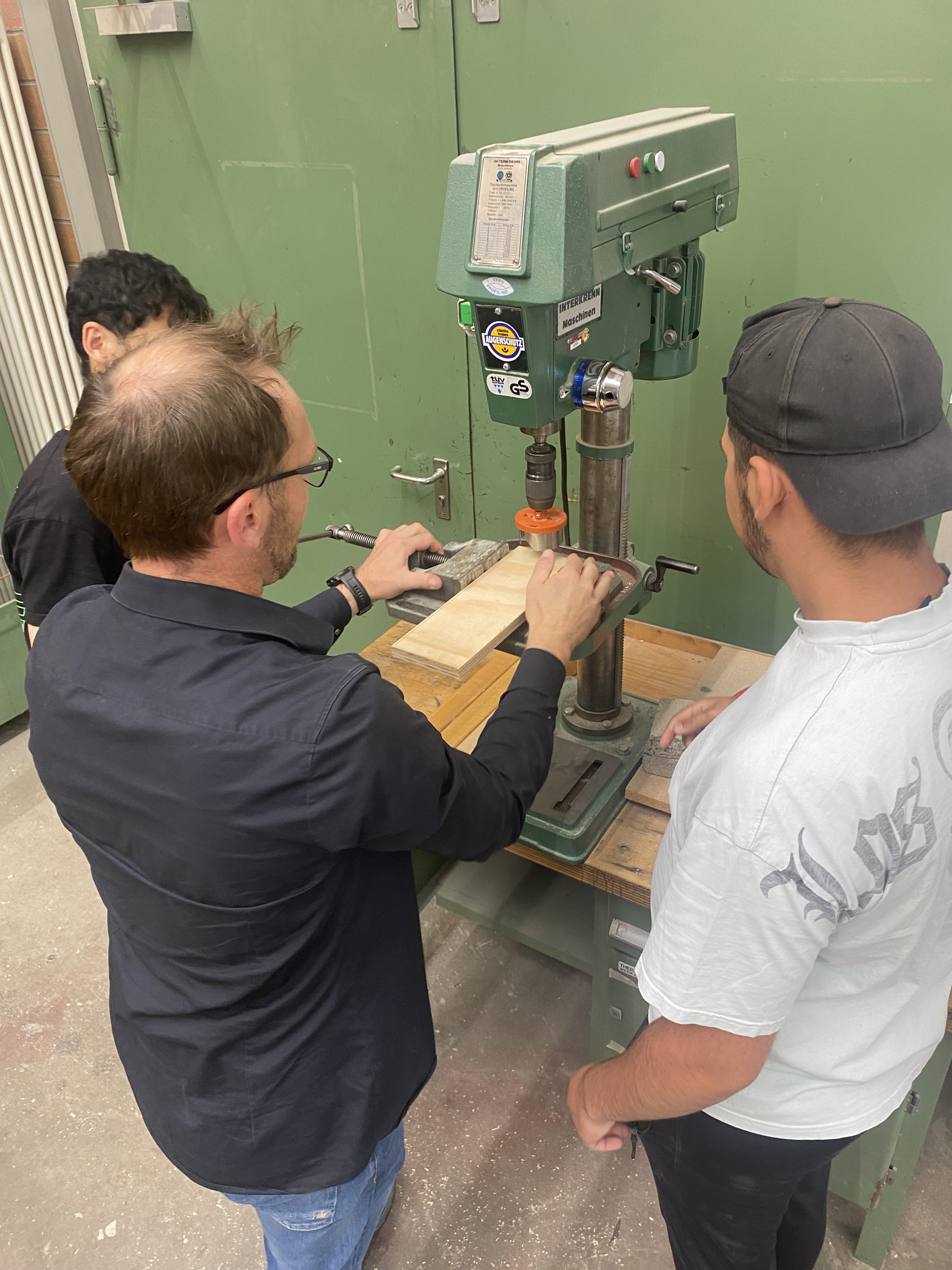 Lehrer und Schüler an einer Säge