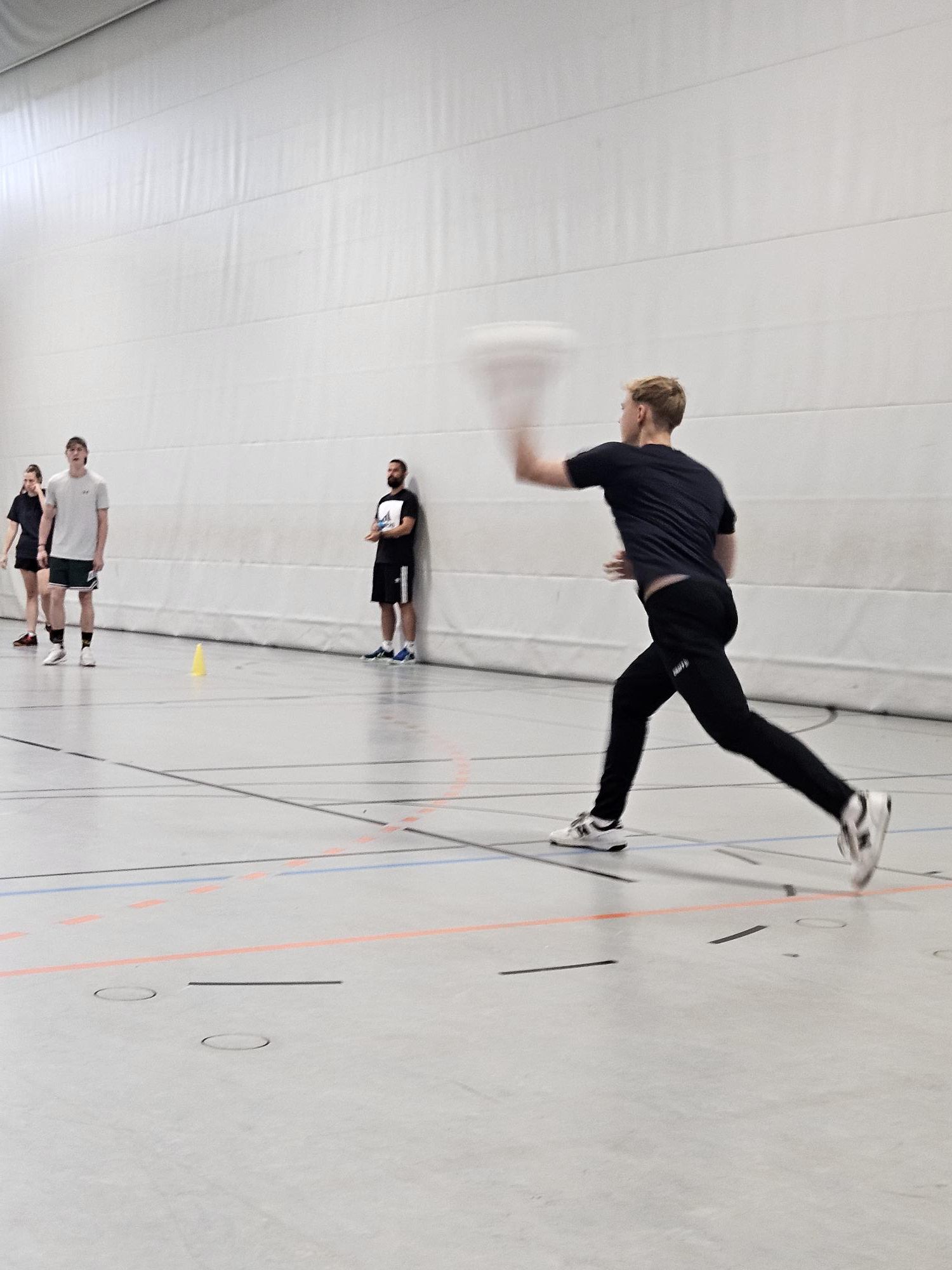 Schüler wirft Ball, mehrere Schüler