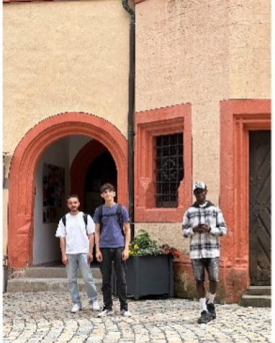 3 Schüler stehen im                                                                                                                                                                           Innenhof der Kaiserpfalz