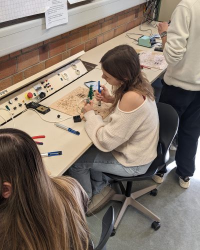 Schülerinnen und Schüler beim Löten