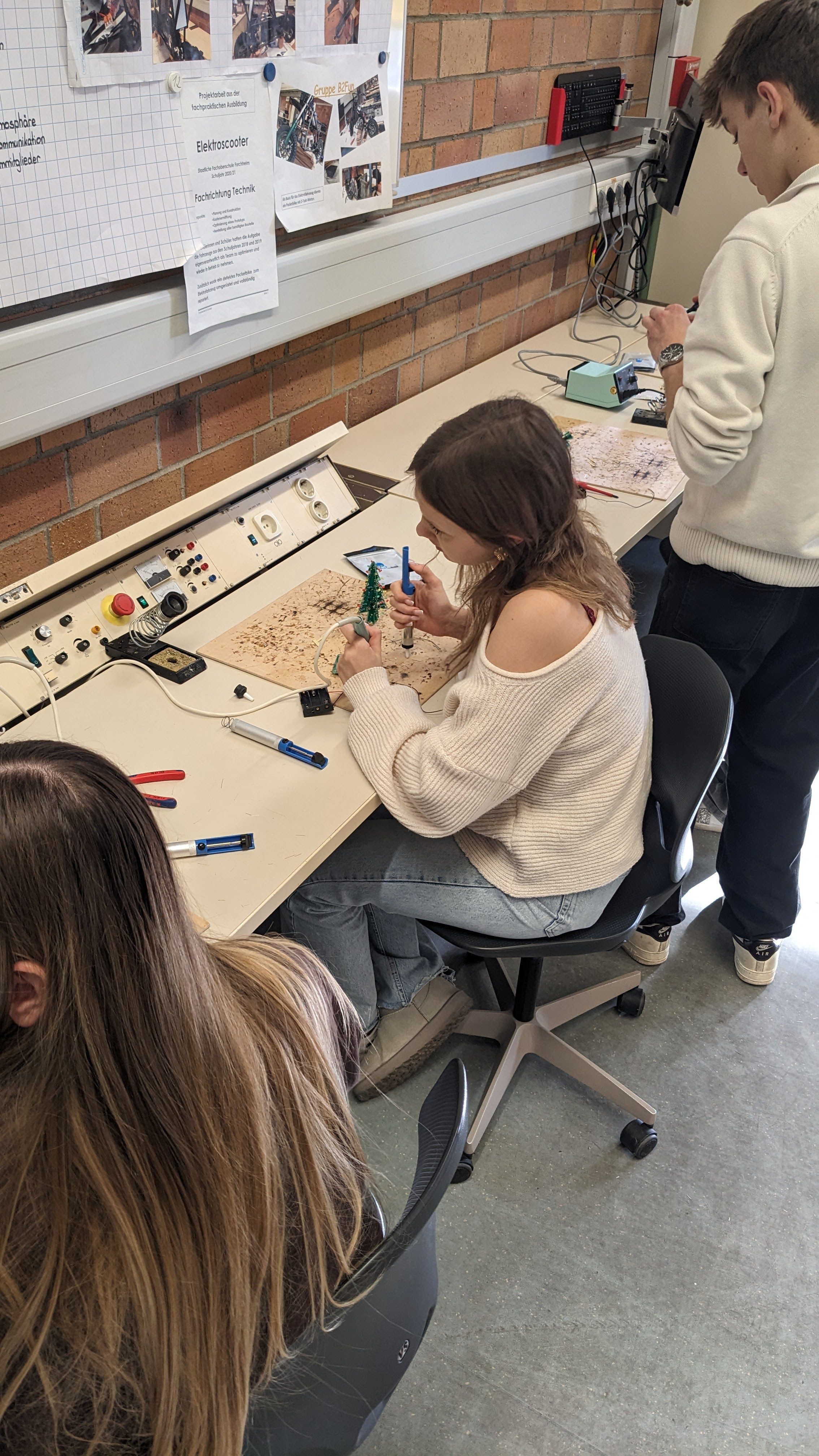 Schülerinnen und Schüler beim Löten