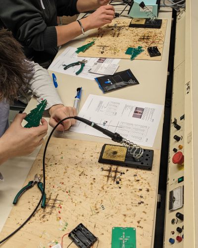 Zwei Schüler löten Tannenbäume