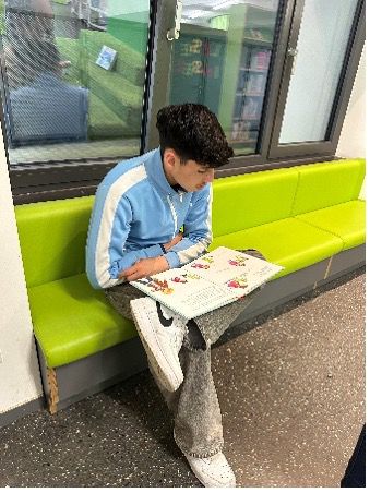 Männliche Person sitzend mit Buch 