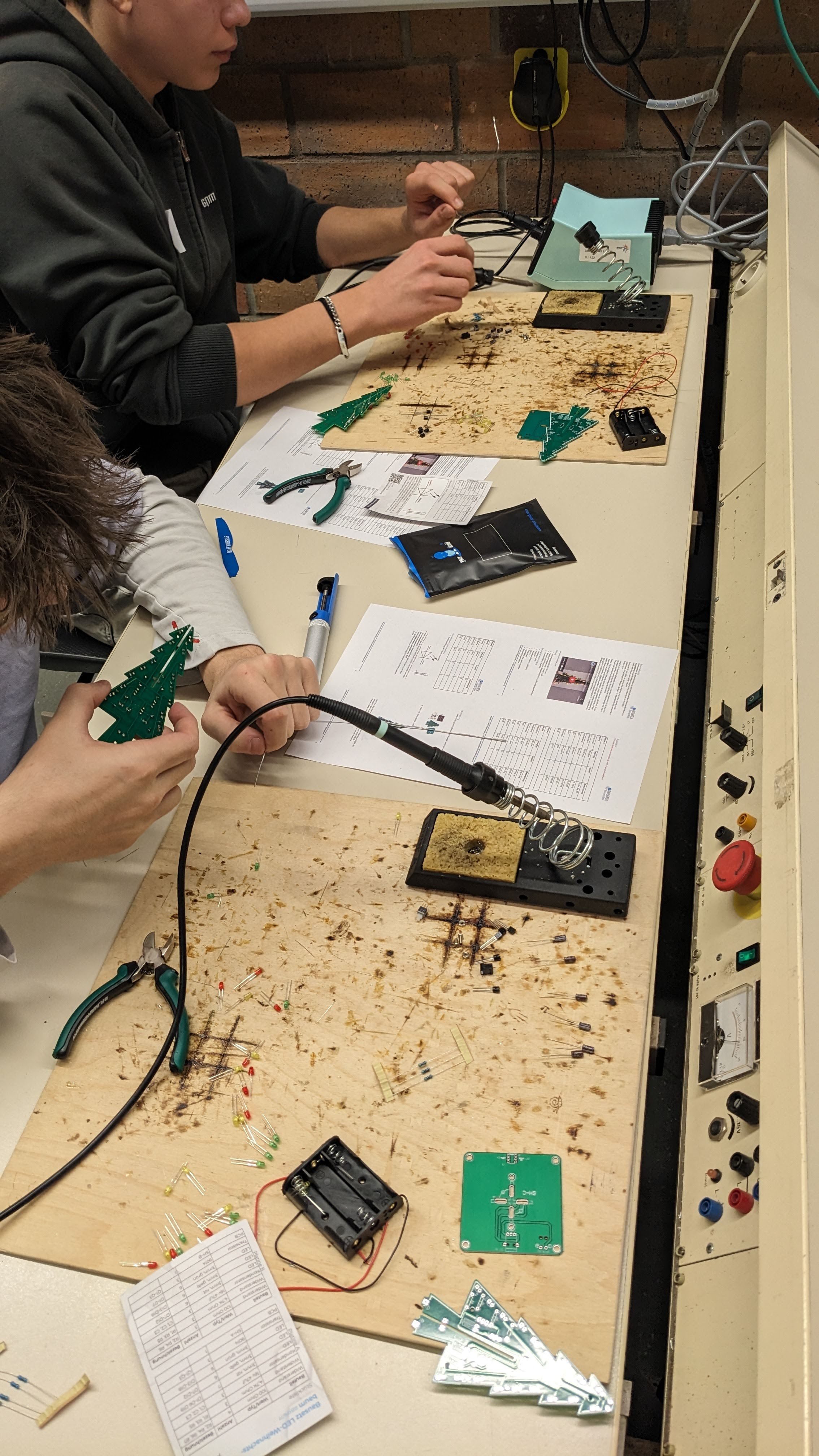 Zwei Schüler löten Tannenbäume