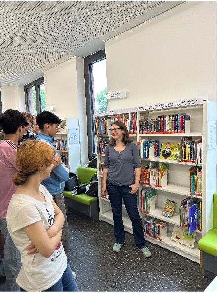 Mehrere Personen stehend vor Bücherregal